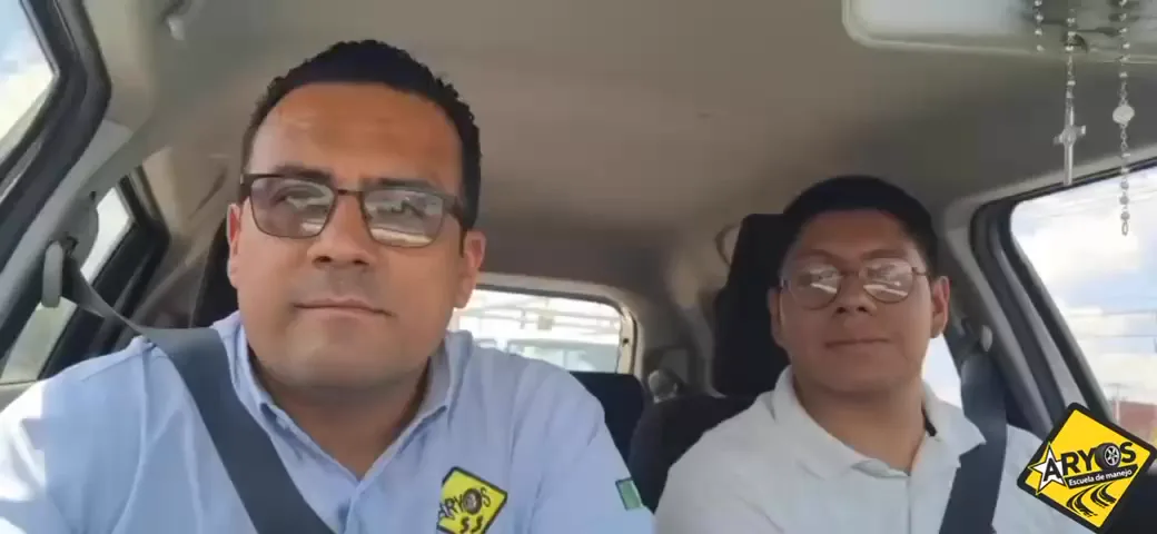 Instructor y alumno con lentes dentro del auto, listos para la clase
